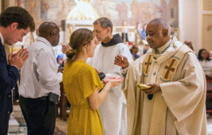 Archbishop Gregory distributes communion during Mass.
