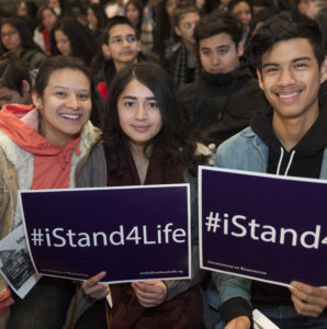 Young adults hold signs at the Youth Rally and Mass for Life