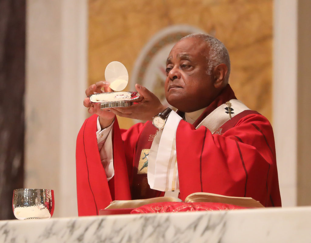 Archbishop Gregory elevates the Eucharist while celebrating Mass at the Cathedral of St. Matthew the Apostle.