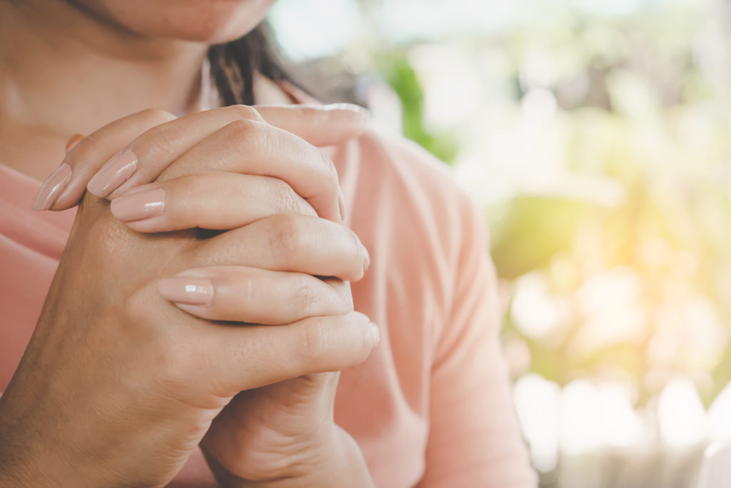 woman-hand-praying-peacefully-outdoors