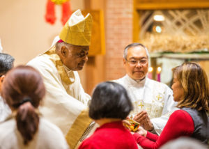 Cardinal Gregory receives the offertory gifts at Mass.