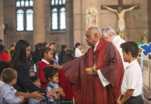 Cardinal Gregory blesses a young student.