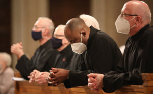 Men religious pray at Mass