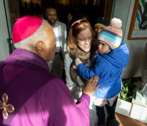 Cardinal Gregory greets a mom and her child after Mass.