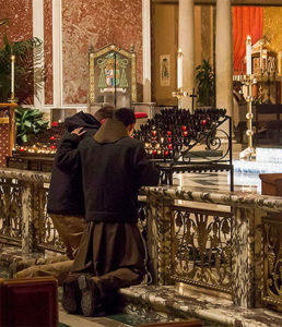 People pray and light a candle at the Cathedral of St. Matthew the Apostle.