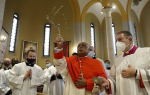 Cardenal Gregory rociando agua bendita