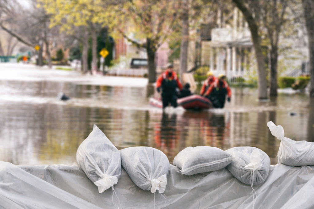 flood-protection-sandbags-with-flooded-homes-in-the-background-montage-2