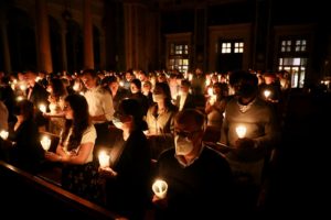 People hold lit candles at the Easter Vigil