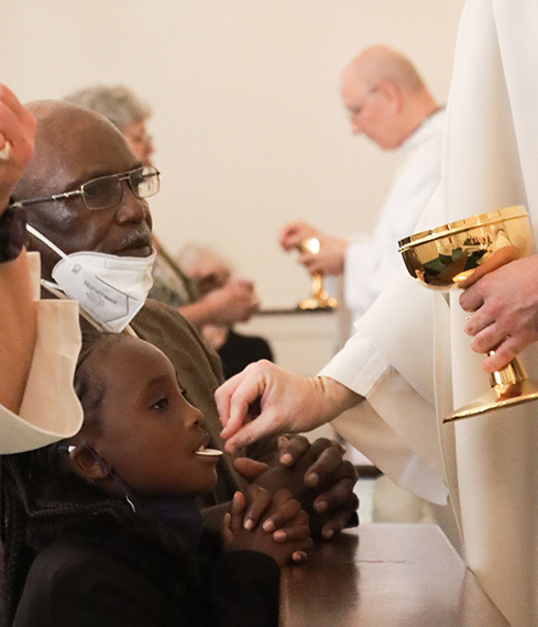 Pastor gives Communion to a girl