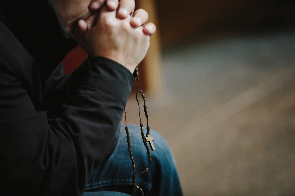 A man prays the rosary.