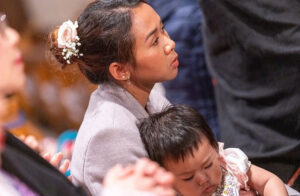 A mother holds her child at Mass