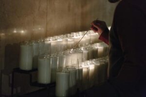 A person lights a candle.
