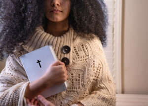 A girl holds a Bible.