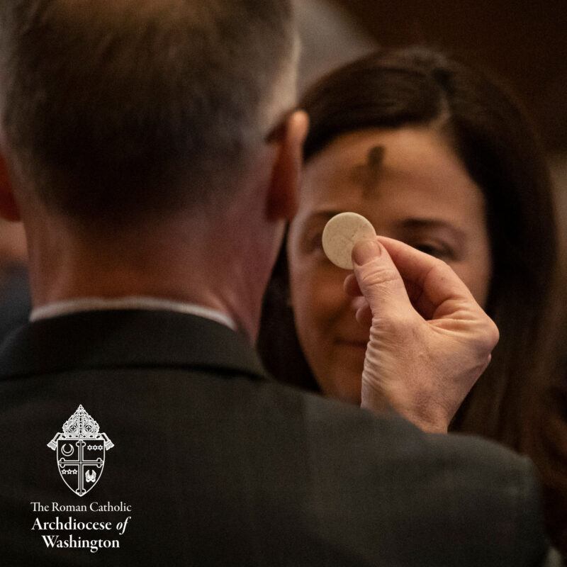 Ash Wednesday photo of Man delivering Eucharist to Woman with Ash Cross on Forehead.