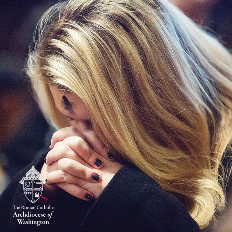 Ash Wednesday Woman bowing head and praying with Ash Cross on forehead