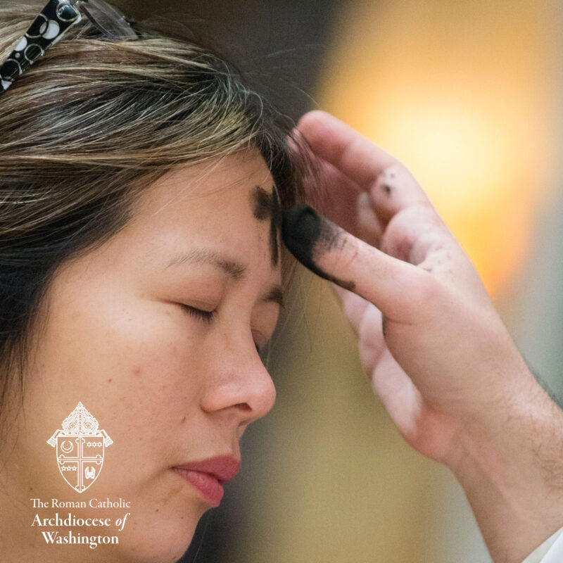 Ash Wednesday Woman receiving Ash Cross on forehead.