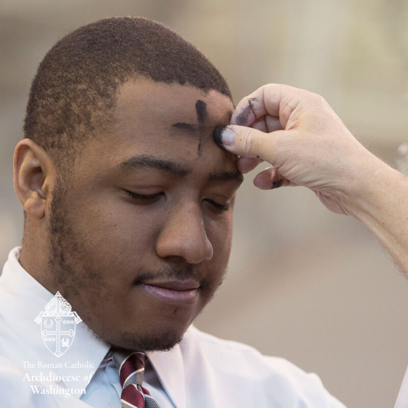 Ash Wednesday man receiving Ash Cross on forehead.